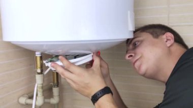 Bir çilingir çalışmayan bir kazanı tamir eder. İşçi elektronik aletleri kontrol edecek ve ayarlanabilir bir anahtarla borunun vidasını sökecek. Teknik yardım kavramı