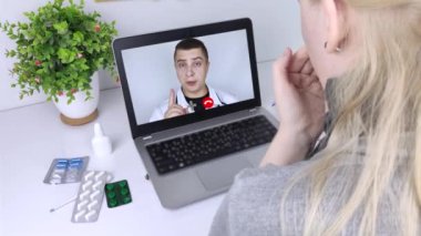Bir kadın video bağlantısıyla doktorla bilgisayar aracılığıyla iletişim kuruyor. Karantina koşulları altında tıbbi yardım. Uzaktan terapistle görüşme.