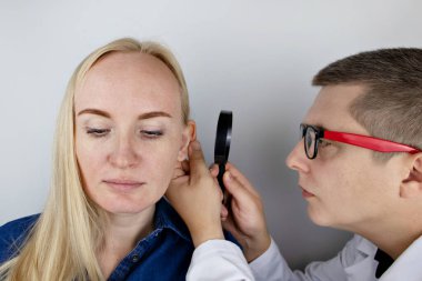 Darwin 'in tüberkülü kulağında. Plastik cerrahın resepsiyonundaki kız, kulaklığı gösteriyor..