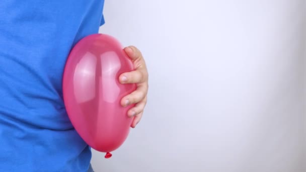 概念的なビデオ 男は腹の近くに赤いボールを持っている 膨満感と鼓腸を象徴する 風船を破裂させるために針を持ってきて問題を取り除く — ストック動画