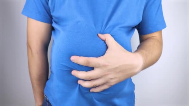 その男は腫れている腹にしがみついている 膨満感 消化管の機能不全 胃や腸の問題の概念的なビデオ — ストック動画