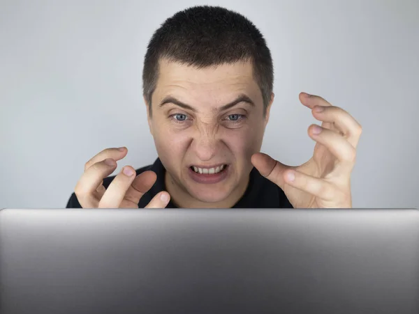 男はノートパソコンを見て そこで見たことに腹を立て いらいらする 感情を表現し あなたがインターネットで見るものに反応します 衝撃的なコンテンツコンセプト — ストック写真