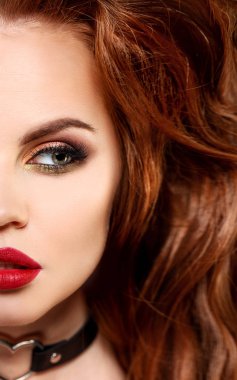 Kız yüz makyaj çarpıcı bir profesyonel ile. Kırmızı dudaklar, sahte kirpik, pudra, allık. Cilt saç modeli üzerinden bukleler. Genç bir model şık saç.