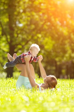 Şirin Bebek anne çim ile yaz Park'ta. tatlı bebek ve anne açık havada. Annem bir yürüyüş ile duygusal çocuk gülümsüyor. bir çocuğun bir gülümseme