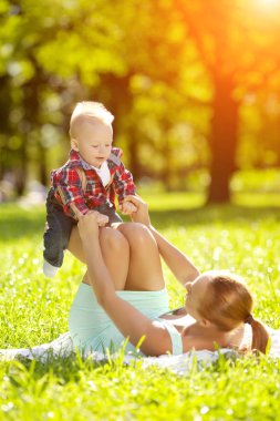 Şirin Bebek anne çim ile yaz Park'ta. tatlı bebek ve anne açık havada. Annem bir yürüyüş ile duygusal çocuk gülümsüyor. bir çocuğun bir gülümseme