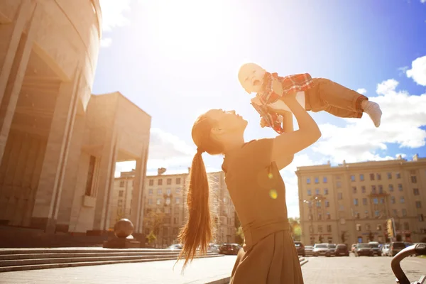 도시의 도시의 풍경에 유행하는 현대적 어머니 엄마는 아이를 다닌다 — 스톡 사진