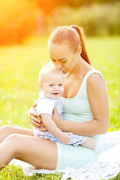 夏は草の上の母親と一緒に公園でかわいい赤ちゃん 甘い赤ちゃんとママの屋外 徒歩でママと感情的な子供の笑みを浮かべてください 子どもの笑顔 — ストック写真