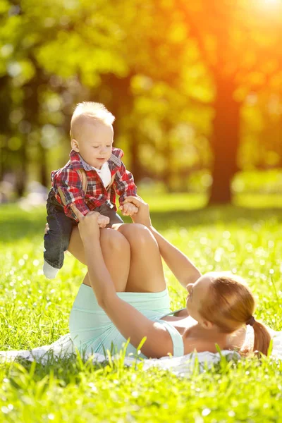 夏は草の上の母親と一緒に公園でかわいい赤ちゃん 甘い赤ちゃんとママの屋外 徒歩でママと感情的な子供の笑みを浮かべてください 子供の笑顔 — ストック写真