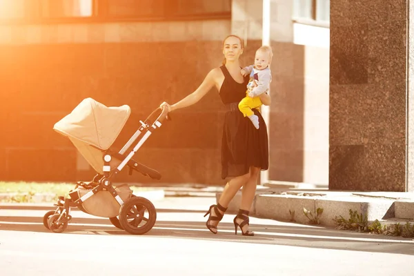 乳母車と街のファッショナブルな近代的な母 若い母親と歩く — ストック写真