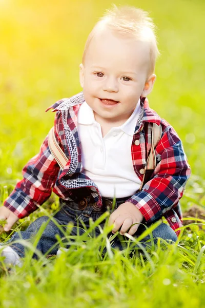 夏の公園の芝生の上にかわいい赤ちゃん 甘い幼児屋外 散歩に感情的な子供の笑顔 子供の笑顔 ストック写真