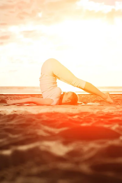 年轻漂亮苗条的女人在日出时在海滩上瑜伽 瑜伽在日落 — 图库照片
