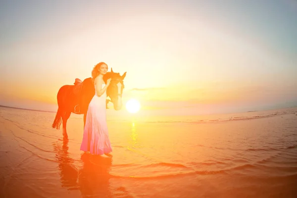 美丽的女人 在日落时分在海滩上骑马 年轻美丽的女孩 与一匹马在海边太阳的光线 — 图库照片