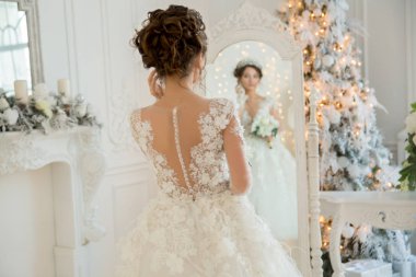 Güzel gelin gelinlik, Noel aynaya. Saç ve makyaj kız tekrarlar.