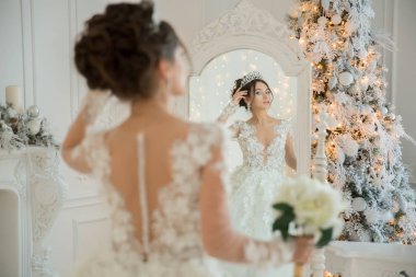 Güzel gelin gelinlik, Noel aynaya. Saç ve makyaj kız tekrarlar.