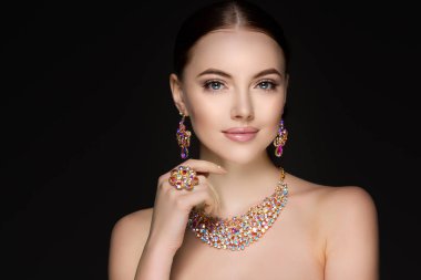 Güzel kadın bir kolye, küpe ve yüzük. Değerli taşlar, elmas takı modeli.
