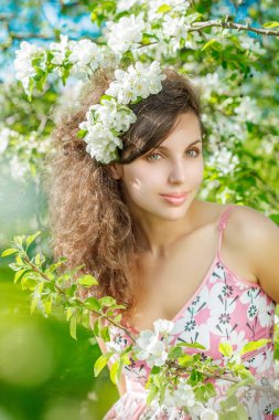 Bahar çiçekleri ile bahar Woman.Beautiful kız modeli. Genç kadın çiçek açan elma ve kiraz bir yaz bahçesi arka plan üzerinde. Polen alerjisi.