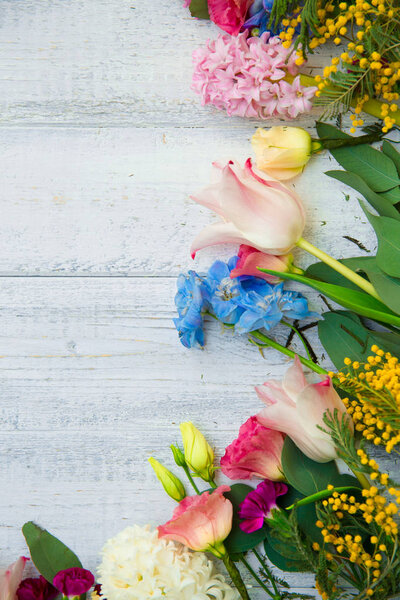 Spring flowers on wood background. Summer blooming border on a wooden table.