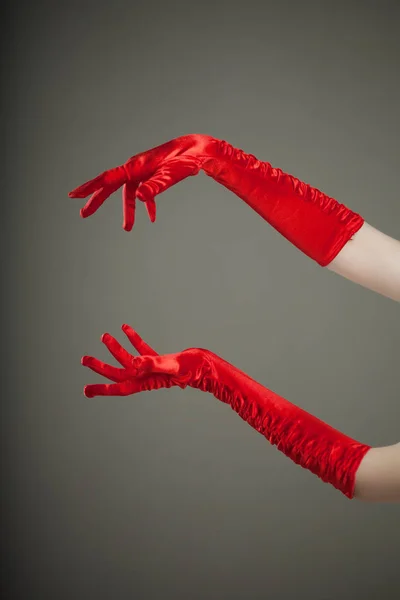 穿着红色丝绸或缎子手套的优雅的空旷的女性手 展示你的产品或文字的自由空间 — 图库照片