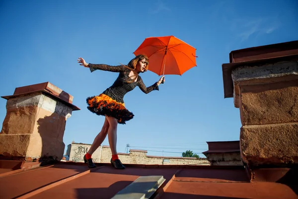 傘で屋根の上の若い美しい女性 空の背景のロマンチックな散歩モデルの女の子 ストック画像