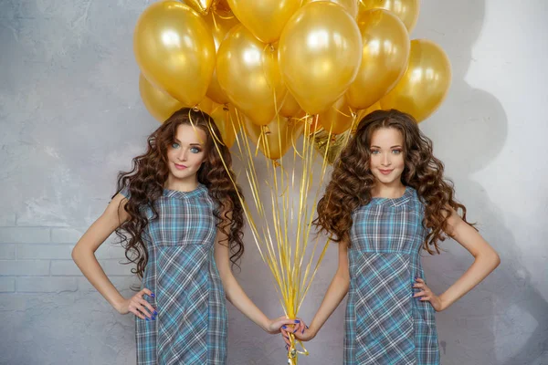黄金の風船や星の背景の作業部会で髪型髪の女の子の双子の姉妹 誕生日パーティーで女性 — ストック写真