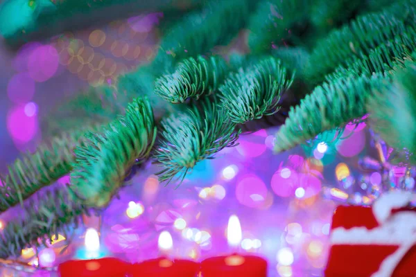 圣诞贺卡新年晚会主题的背景 装饰冷杉树与礼品和蜡烛的背景下丰富多彩的节日彩灯 一个神奇的夜晚 图库照片