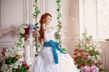 Güzel kız modeli Prenses çiçekli sarayında. Beyaz bir elbise içinde gelin. Lüks bir vintage iç kadında.