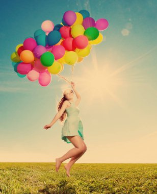 Lüks moda ve kadın ile balonlar alanında gökyüzüne karşı elinde güneşte