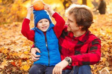 Baba ile oğlu sonbahar parkta yürüyor. Bir çocuk ve bir adam ormanda yürüyüşe eğleniyorlar. Aile doğada zaman harcıyor