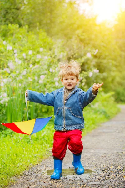 Ребенок Прыгает Лужах Сапогах Ребенок Дождем Мальчик Радужным Зонтиком Выходит — стоковое фото