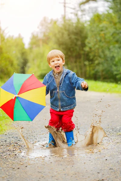 Barnet Hoppar Pölar Stövlar Baby Regnet Pojke Med Regnbåge Paraply — Stockfoto