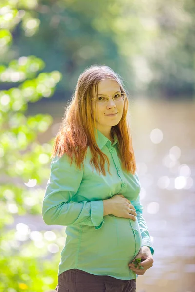 自然の背景に妊娠中の女性 おなかを持つ美しい少女モデル — ストック写真