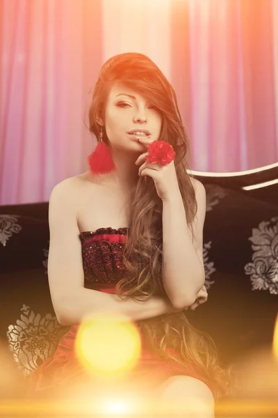 美丽的年轻模特女子在一个童话般的晚红色礼服在一个仙女豪华的公寓 美丽的化妆和金色的头发 经典的复古家居内饰 夜总会的光线 — 图库照片