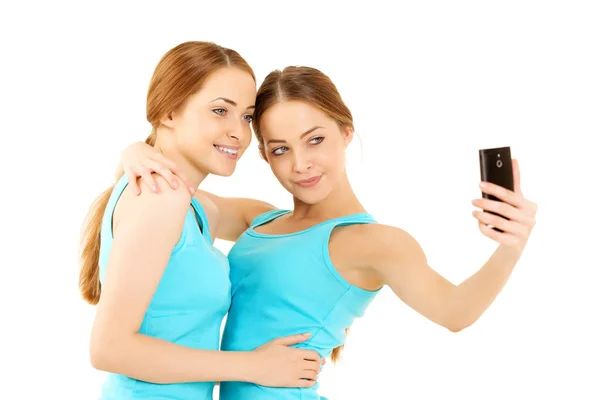 社交网络的自拍时间到了 双胞胎 女孩模特 两个微笑的女人把照片拍到手机上 — 图库照片