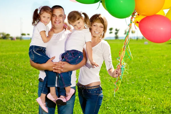 幸福的家庭举行户外的五颜六色的气球 Ded 和两个女儿玩 — 图库照片
