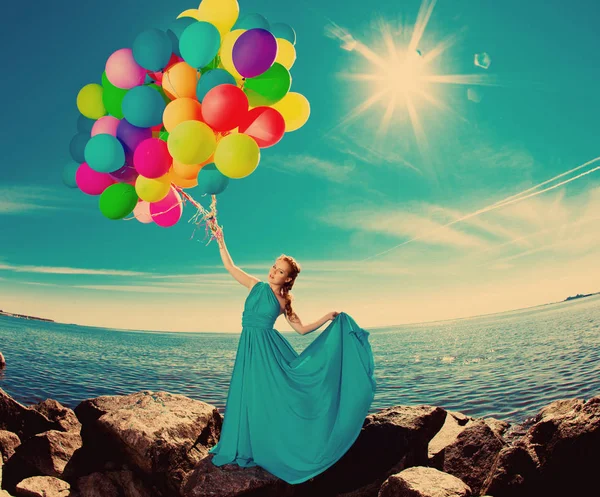 豪华时尚女子与气球在海滩上反对天空和太阳在长的 Dres — 图库照片