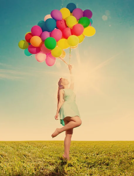 豪华的时尚女人与气球在手的领域对天空和太阳 — 图库照片