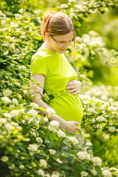 自然の背景に妊娠中の女性 おなかを持つ美しい少女モデル ストックフォト