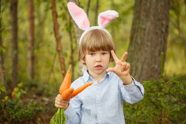 森でニンジンとスーツ バニーの男の子 ウサギの耳を持つ子 — ストック写真