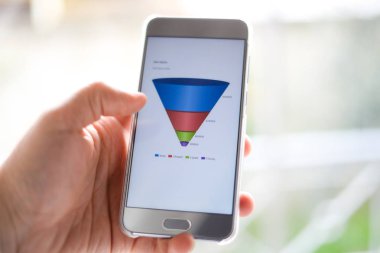Erkek el ile pazarlama satış huni grafiğe bir akıllı telefon tutarak