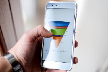 Erkek el ile pazarlama satış huni grafiğe bir akıllı telefon tutarak