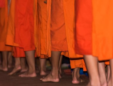 Rahipler yakın çekim ayakları. Rahipler besleme. Ritüel denir Tak yarasa, Luang Prabang, Laos