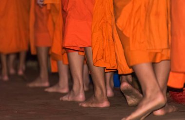 Rahipler yakın çekim ayakları. Rahipler besleme. Ritüel denir Tak yarasa, Luang Prabang, Laos
