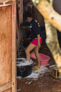 Luang Prabang, Laos - 11 Ocak 2017: Kadın ayağı havzasında daldırma. Dikey