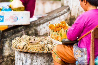 Kadın kurban muz ve çiçekler, Luang Prabang, Laos yaprakları satıyor. Yakın çekim