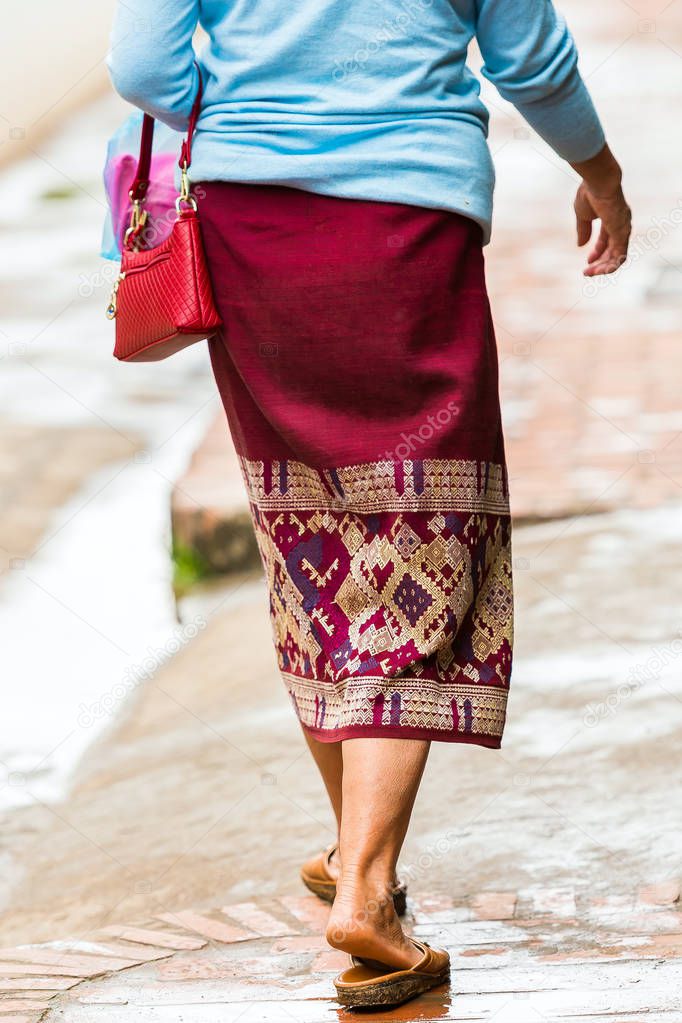 Woman in a skirt on a city street, Luang Prabang, Laos. Close-up. Vertical