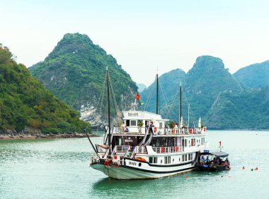 Halong, Vietnam - 16 Aralık 2016: Bay kayaların arasındaki turistik gemi. Metin için yer kopyalayın