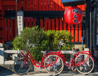 Kyoto, Japonya - 7 Kasım 2017: İki kırmızı bisiklet üzerinde bir şehir sokak
