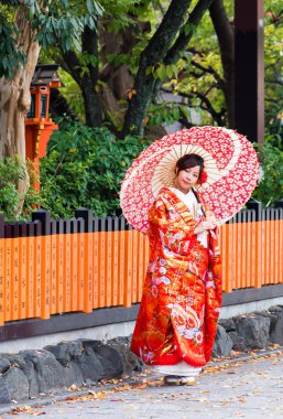 Kyoto, Japonya - 7 Kasım 2017: Bir kimono bir şehir sokak üzerinde bir şemsiye ile bir kız. Dikey. Metin için yer kopyalayın