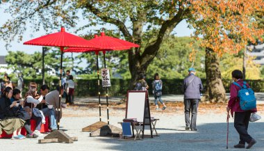 Odawara, Japonya - Kasım, 11, 2017: Şövale kırmızı şemsiye altında çizim için. Metin için yer kopyalayın  