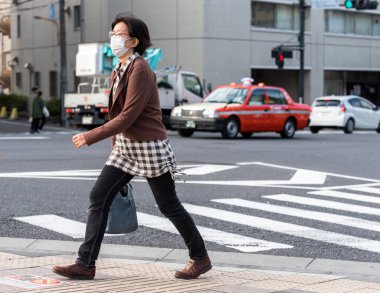 Tokyo, Japonya - 7 Kasım 2017: Bir şehir sokak üzerinde beyaz bir tıbbi maske bir kadın. Metin için yer kopyalayın